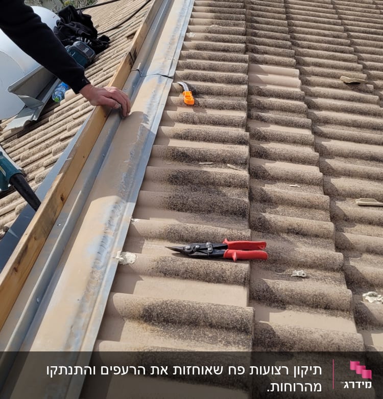 עבודת תיקון על גג רעפים עם כלי עבודה